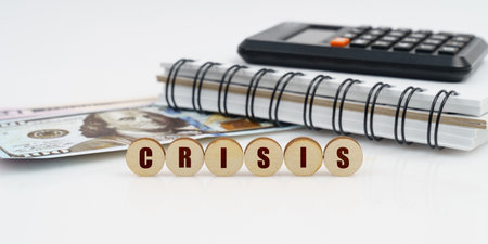 Business and finance concept. On a high surface lie a notepad, a calculator, dollars and wooden...