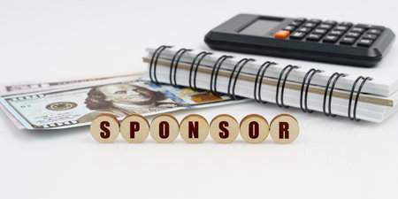 Business and finance concept. On a high surface lie a notepad, a calculator, dollars and wooden...