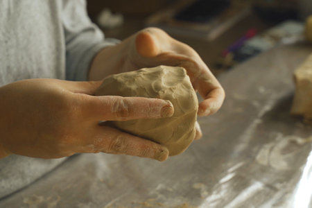 A woman makes a craft from clay. Close-up of hands.の写真素材