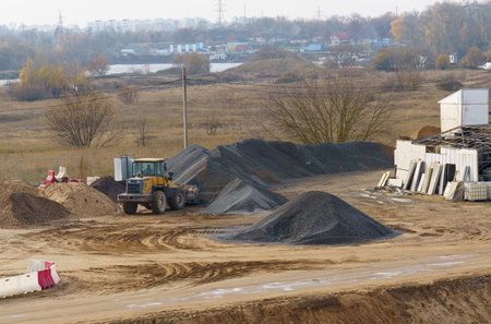 A bulldozer is parked in the dirt near a pile of dirt, likely after executing excavation work in a construction site.の写真素材