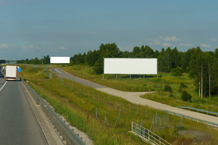 An empty billboard stands beside the road, awaiting a message or advertisement to capture passing drivers attention.の写真素材