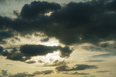 The sun breaks through the clouds, creating rays of light in the sky.の写真素材