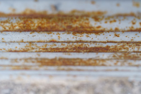 A detailed view of a rusted metal surface, showing the texture, color, and pattern formed due to...