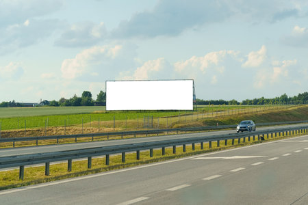 A bill massiveboard advertising various products and services positioned prominently on the side of a bustling highway.の写真素材