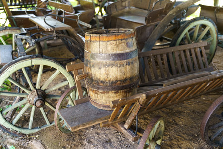 An old-fashioned wooden cart carrying a wooden barrel on top of it.の写真素材