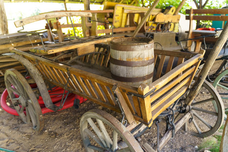 A wooden wagon with a barrel attached to its back, standing in a field.の写真素材