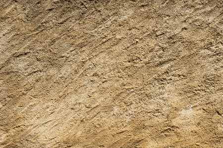 A detailed close-up of a textured sand background with intricate patterns and variations in color.の写真素材
