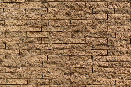 Close-up view of a textured brick wall, showing the intricate patterns and details of individual stones creating an abstract composition.の写真素材