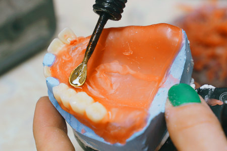 The dental technician makes a wax base and adds wax to form the mold. Dental concept