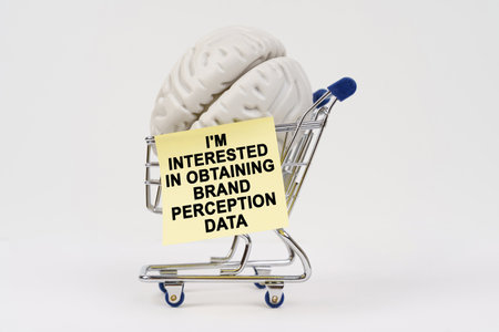 A brain sits in a shopping cart, accompanied by a note expressing interest in gathering brand perception data, merging consumerism with cognitive themes.の写真素材