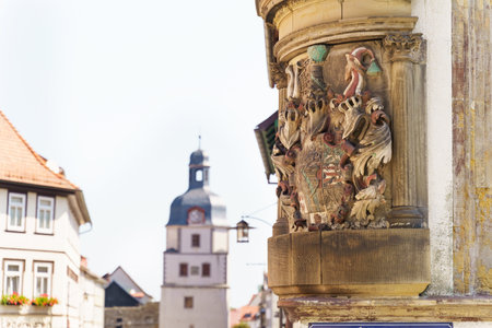 Delicate and colorful reliefs adorn the corner of a historic building in Waltershausen, highlighting craftsmanship from a bygone era against a clear blue sky.の写真素材