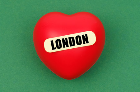 A bright red heart with a label reading London sits against a green background, embodying affection for the capital city.の写真素材