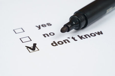 A marking pen rests beside a checkbox survey indicating three possible responses. The selected option shows a clear preference for uncertainty amidst a thoughtful evaluation.の写真素材