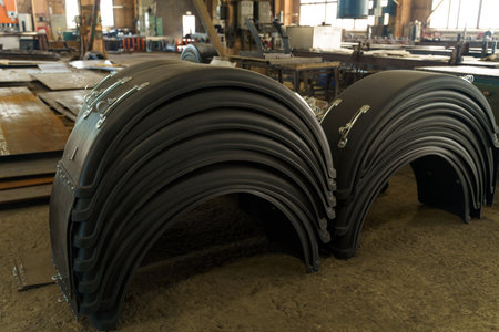 Sturdy rubber parts are neatly stacked in an industrial workshop, reflecting a well-organized manufacturing environment, with tools and machinery in the background indicating active production.の写真素材
