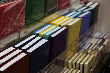 A vibrant assortment of notebooks is neatly arranged on metal shelves. The variety of colors and sizes invites creativity and inspires ideas in a welcoming bookstore environment.の写真素材