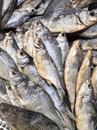 The market's lively atmosphere, filled with the aroma of seafood, showcases an array of dried fish neatly laid out on display cases.の写真素材