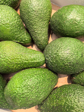 A bountiful arrangement of ripe, green avocados showcases their smooth skin and perfect shape....