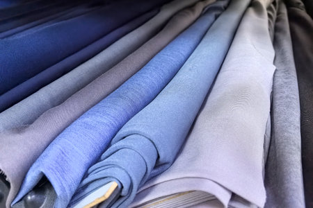 Soft, flowing fabrics in different shades of blue are neatly arranged, showing their textures and colors.の写真素材