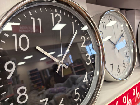 Two sleek wall clocks hang on a display rack, showing their elegant designs and functionality. The ambient light highlights their stylish features, inviting potential buyers.の写真素材