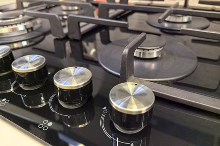 Featuring a stylish gas cooktop, the setup showcases a blend of functionality and modern aesthetics. The shiny knobs promise precision for a variety of cooking techniques and meals.の写真素材