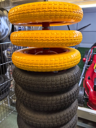 A vibrant arrangement of toy wheels in a workshop, with bright yellow wheels on top of sturdy black ones, showcasing creativity and fun. Perfect for imaginative play or DIY projects.の写真素材