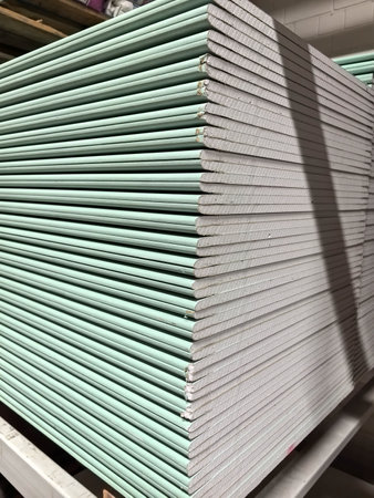 Neatly organized stacks of green building panels fill the warehouse, showing the structured arrangement of materials awaiting use in future construction projects in broad daylight.の写真素材