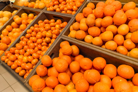 Baskets overflow with bright oranges in a lively market. Shoppers explore the colorful produce, enjoying the fresh aroma and vibrant hues, creating an inviting atmosphere for all.の写真素材
