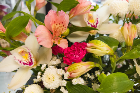 A delightful bouquet features an array of flowers in soft pinks, whites, and lush greenery. The composition displays elegance and charm, perfect for any occasion.の写真素材