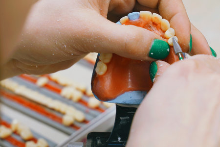 Dedicated dental technician focuses on fabricating perfect dentures, expertly grinding and refining...