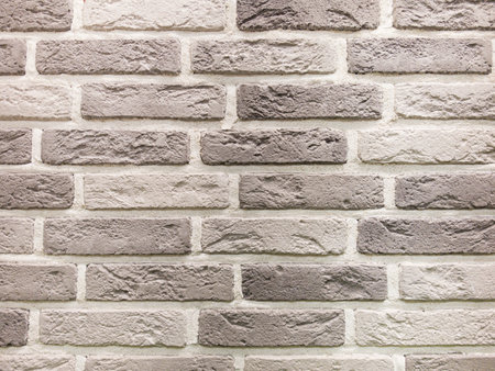 Close-up view of textured decorative tiles showcasing a blend of white and gray hues. The pattern adds depth and character to contemporary wall designs, perfect for various interior settings.の写真素材