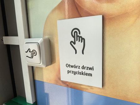A close-up view of an informational sign instructing individuals to open a door by pressing a...
