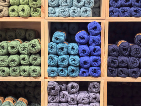 A vibrant display of yarn in various colors showcases neatly organized skeins in wooden boxes. Different shades create a visually appealing arrangement perfect for inspiring creative projects.の写真素材