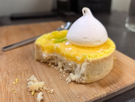 A tempting dessert features a bright yellow filling topped with a fluffy white meringue. The tart...