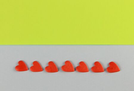 red hearts on a blue and light green background laid out in a row.