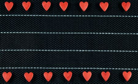 Red hearts in a row, black background. Valentine's Day. Copyspace love concept.の写真素材