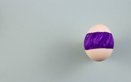 one colored egg on a blue background. copyspace for text.の写真素材