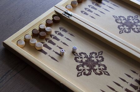 backgammona game of backgammon made of wood lies on a table.