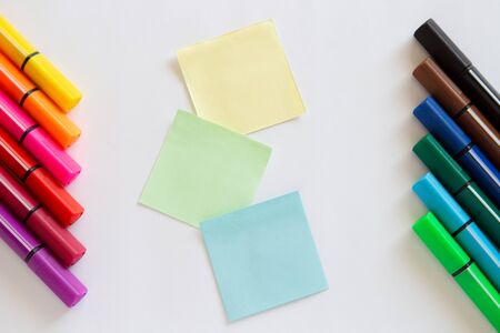 colored markers and stickers lie on a white background. copyspace for textの写真素材
