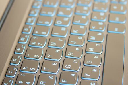 Close-up of laptop keyboard backlight, blue backlit keyboard