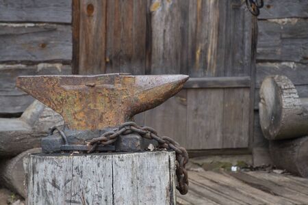 the anvil stands on a stump, lies a chain. The door to the old house.