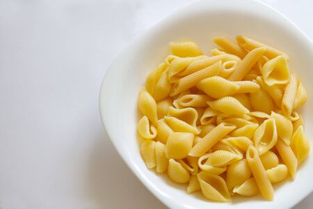 Spaghetti pasta in a white dish on a white background.copyspace for text.
