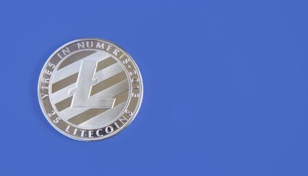 Large silver physical Litecoin on a blue background, virtual money. copyspace for textの写真素材
