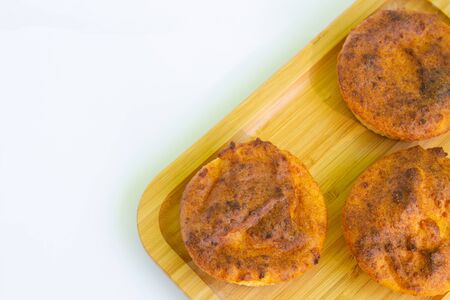 Wooden board with tasty cupcakes on a white plate, top view.copyspace for textの写真素材