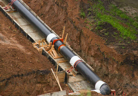 Laying a heating main in a trench to provide water to a settlement