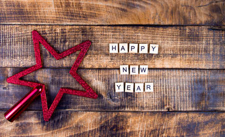 Happy new year lettering on dark wood texture background, star decorationの写真素材