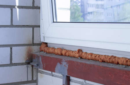 Installed plastic window with polyurethane foam, inside view. Construction concept