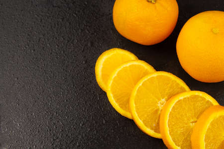 whole fruits and orange slices on a black background. space for text