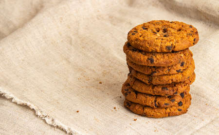 Homemade chocolate chip cookies lie in a stack on a gray clothの写真素材