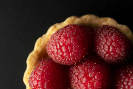 Raspberry tart, top view macro photography. Homemade raspberry tart on the black background.の写真素材