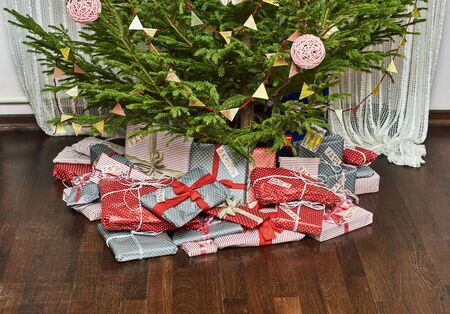 Celebration of New Year at home. Many gifts lying under Christmas tree.の写真素材